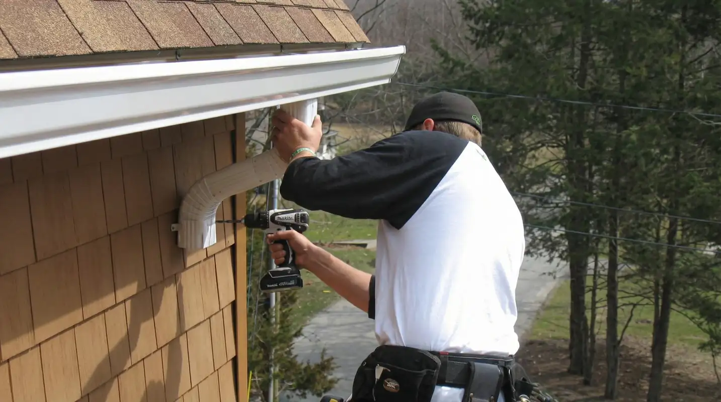 Professional contractor installing tan vinyl siding panels on a residential home exterior in Sarasota, FL